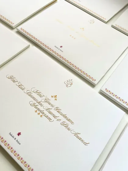 A close-up of the wedding invitation calligraphy. The mix of a traditional design with elegant, handwritten names creates a beautiful balance.