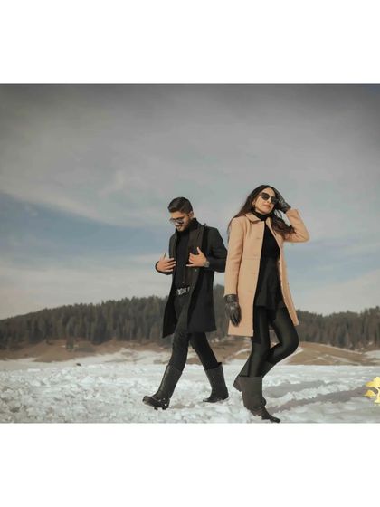 A cool, back-to-back pose against the vast snowy landscape of Kashmir. This shot has a modern and stylish feel.