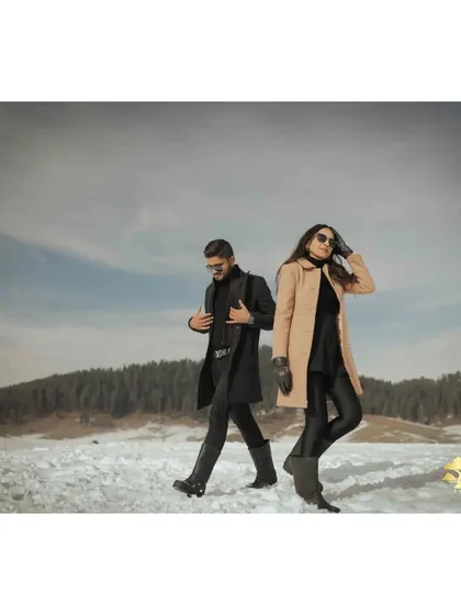 A cool, back-to-back pose against the vast snowy landscape of Kashmir. This shot has a modern and stylish feel.