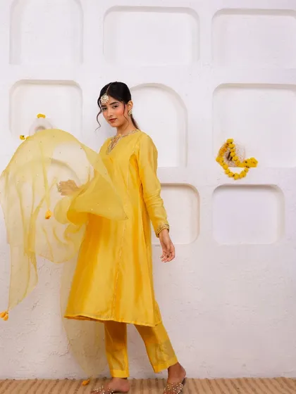 A full-length shot showing the beautiful flow of the yellow suit. It's a classic silhouette that is both comfortable and incredibly chic for any festive occasion.
