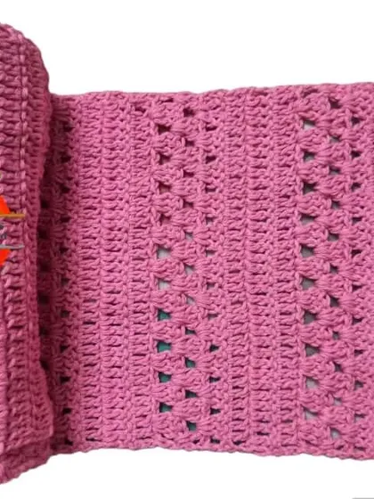 This pink scarf, made with a simple but elegant stitch, was created for a Guinness World Record event. It's rolled up to show its generous length and soft texture.