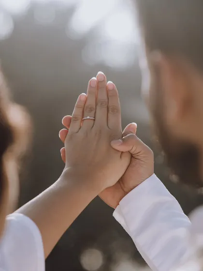 A close-up on the bride's hand, showcasing her engagement ring as the groom holds it gently. A beautiful shot symbolizing their commitment.