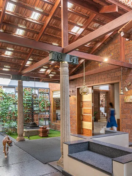 I love creating modern interpretations of the traditional Indian courtyard. Here, reclaimed wooden pillars and a terracotta tile roof frame a central green space, making for a grand yet welcoming entrance that feels rooted in heritage.