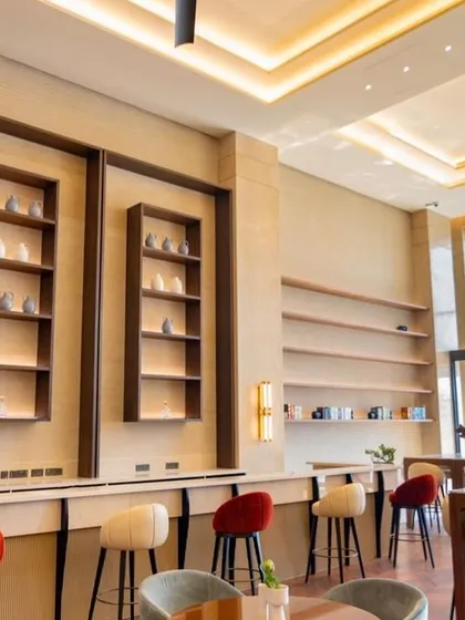 The bar area is designed as a stylish and functional hub within the clubhouse. Clean lines, high-stool seating, and integrated shelving create a sophisticated spot for residents to socialize and unwind.