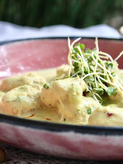 A close-up of our Chickpea Gnocchi, showing the creamy texture of the saffron sauce and the delicate microgreens on top. It's a truly handcrafted meal that will love you back.