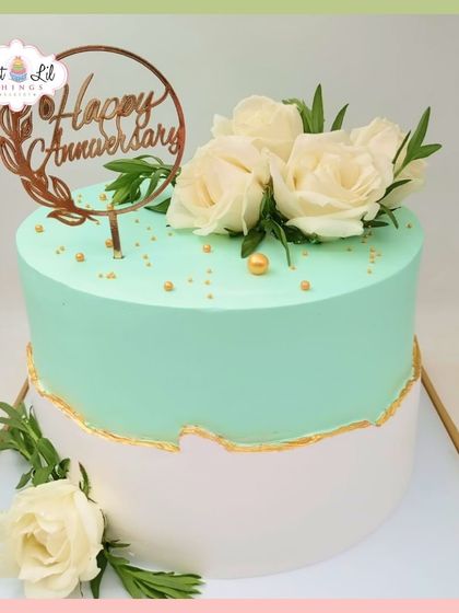 A fresh and elegant anniversary cake. This mint green and white cake is decorated with a simple gold fault line and fresh white roses.