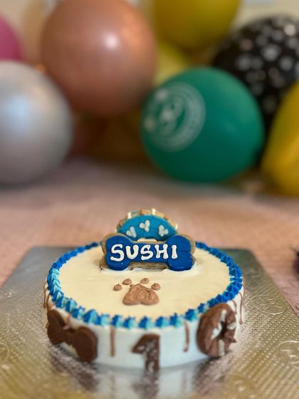 A close-up of Sushi's beautiful blue drip cake, topped with an edible bone. Our drip cakes are a stylish and modern option.