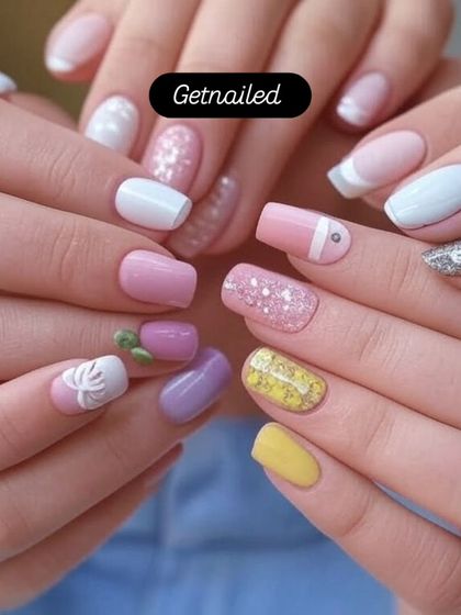 A fun, multi-colored pastel set perfect for spring, featuring different colors and designs on each nail, including glitter and 3D art.
