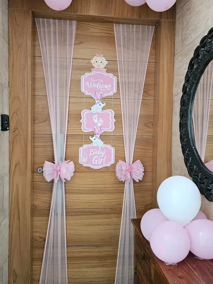 The 'Welcome Baby Girl' door decor shown with some balloons at the side, giving an idea of how it looks as part of a larger home decoration.