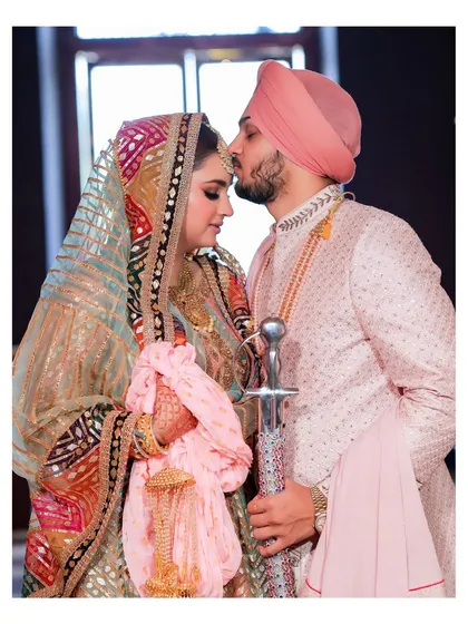 We aim to create portraits that are both powerful and tender. This image of a Sikh couple captures the groom's gentle kiss on the bride's forehead, a beautiful moment of affection during their Anand Karaj ceremony.
