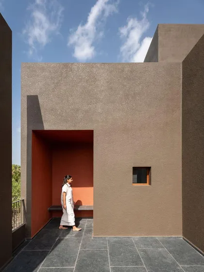 An upper-level terrace offers a private open-to-sky space, with a pop of color inside a niche providing a moment of visual delight.
