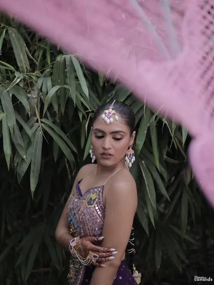 An artistic shot of the bride, with her long, neat braid visible against a natural backdrop, highlighting the simplicity and elegance of the style.