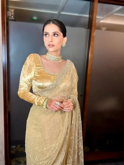 A full view of the client's elegant look, featuring a sleek low bun. This minimalist hairstyle is perfect for showcasing her velvet blouse and statement jewelry.