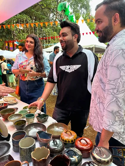A group of friends checking out the handmade pottery at my festival stall. Events like these are a fantastic way to spend a weekend, surrounded by art, music, and creative energy.