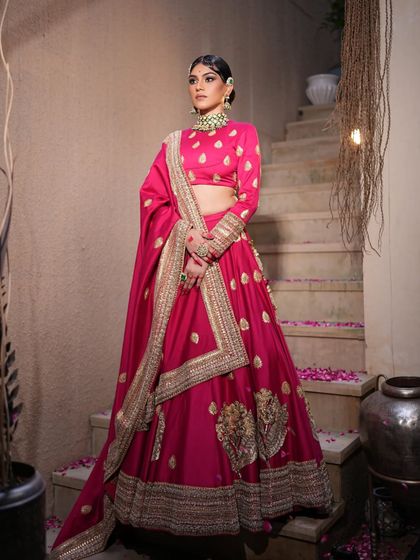 A full view of the magenta lehenga, showcasing its simple yet elegant design with a heavy embroidered border.