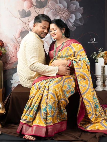 A tender moment captured during a traditional saree photoshoot. The couple's loving embrace and the beautiful ethnic wear make this a truly special portrait.