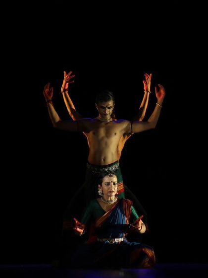A creative pose from 'Nagamandala', where one dancer is seated and another forms a backdrop. This layering of bodies is a technique I use to create depth and meaning in my choreography.