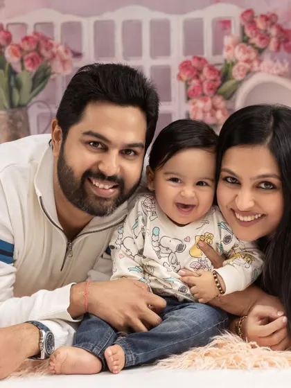 The best smiles are the unscripted ones. This candid style family portrait captures a genuine moment of happiness, set against one of our beautifully arranged floral backdrops in the studio.