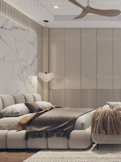 A close-up of the plush, channel-tufted bed, set against a backdrop of a marble slab and fluted wall panels.