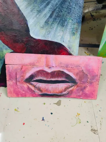 A close up painting of lips on a block of wood. This older piece is available for sale.