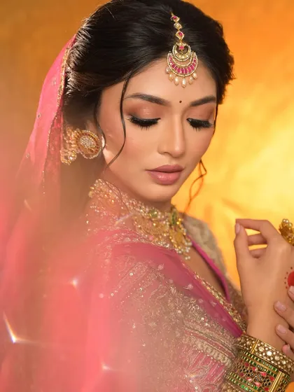 An artistic shot with a soft, dreamy filter, highlighting the bride's delicate features and the beautiful pink tones of her look.