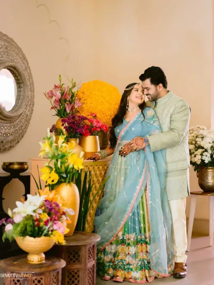 A beautiful portrait from a destination wedding at Alila Bishangarh, with the couple framed by vibrant flowers, showcasing the color and joy of their celebration.