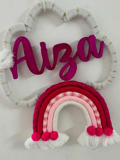 A beautiful name hanging for 'Aiza' in shades of pink and red. This piece includes a gold-threaded cloud frame for an extra touch of sparkle.
