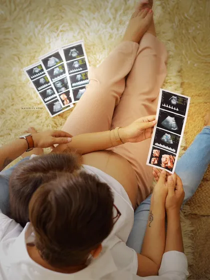 An overhead shot of the couple looking at their ultrasound scans together. This creative angle adds a unique, intimate perspective to their story.