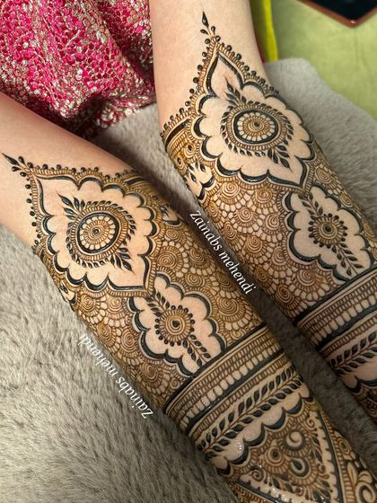 A symmetrical view of Arsha's bridal henna on both arms, highlighting the clean lines and detailed patterns.