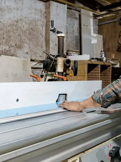 A craftsman at our factory uses a routing machine for precision detailing. This attention to detail is what sets our custom kitchens apart.