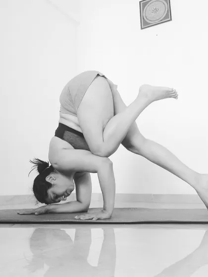 A black and white still of a funky Pincha variation. Exploring different leg positions helps you understand your center of gravity.