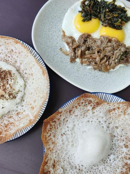 A perfect Sunday breakfast featuring our Pandi Curry. It's served here with soft appams, fried eggs, and sautéed oyster mushrooms for a complete and hearty Kodava-style meal.
