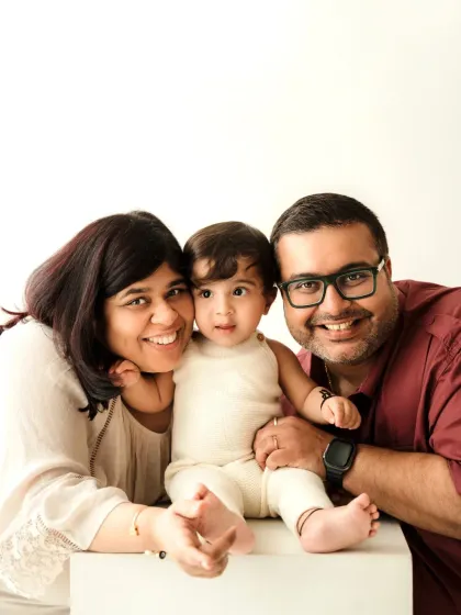 A happy little family of three smiling for the camera. This classic portrait is perfect for capturing a key moment in their family's life.