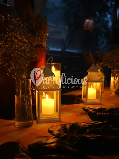 The warm glow of lanterns and candles at our tribal-themed party, creating an intimate and earthy ambiance as night falls.