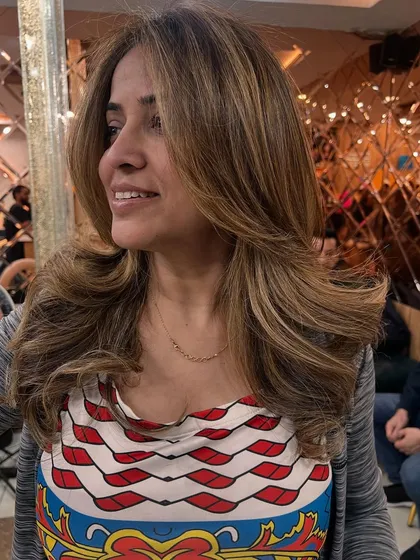 A gorgeous, voluminous blowout on freshly colored hair. The style perfectly showcases the multi-tonal highlights and the healthy condition of the hair.