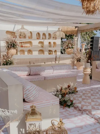 Low, comfortable seating with custom striped cushions and bolsters, set against a wall with decorative niches. This design choice provided ample seating while maintaining the open, airy feel of the venue.