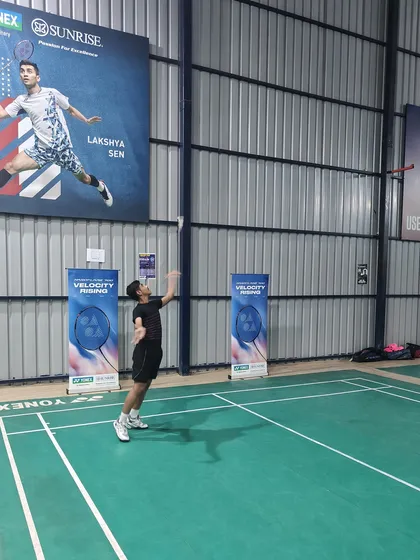A student practices his overhead clear during the Yonex event. These community events combine learning with practical application on the court.