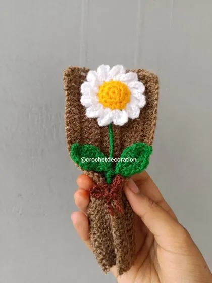 A mini daisy bouquet held in hand against a neutral background, highlighting its charming simplicity.