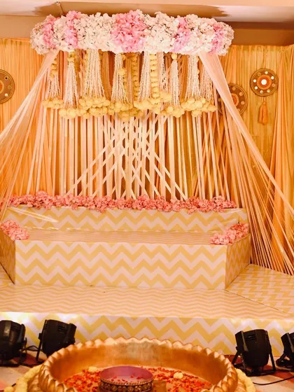 The Haldi stage setup before the ceremony begins, showing the beautiful arrangement of flowers and drapes.