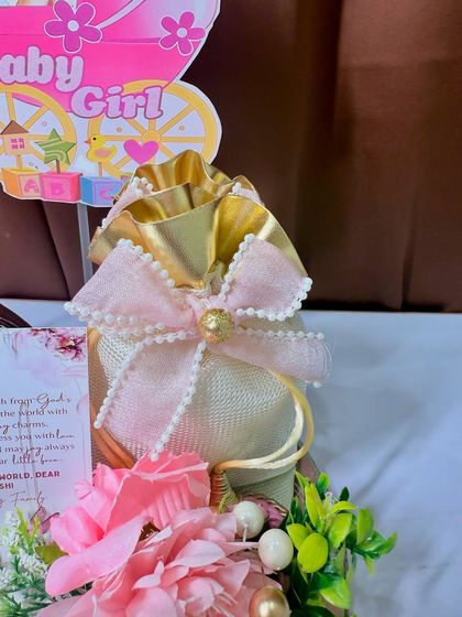 The golden potli bag adds a touch of luxury to this baby announcement hamper.