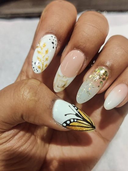 A whimsical and elegant set featuring a monarch butterfly wing, gold foil, marble effects, and delicate leaf patterns. Each nail is a unique piece of art.