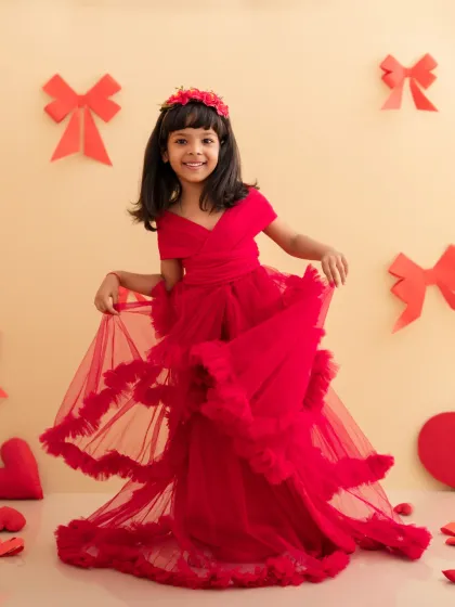 This little girl is a vision in red, twirling her beautiful ruffled dress in our sweet Valentine's Day setup with hearts and bows.