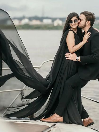 A romantic kiss on the ear, made more dramatic by the billowing black trail of the gown. This dress is designed for creating memorable, high-impact photos.