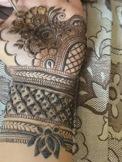 A close up shot of a Karwa Chauth design in progress. You can see the fine lines and details that go into creating these full-hand patterns.