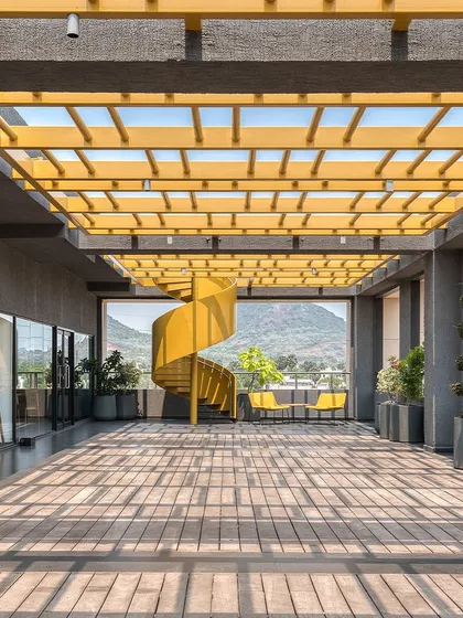 This vibrant yellow spiral staircase is the centerpiece of the Laurus Labs corporate office in Vizag. The design creates a dynamic, light-filled breakout space with stunning views, reflecting a modern approach to workplace architecture that encourages interaction and well-being.