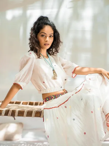 A bohemian-inspired hairstyle for a fashion shoot. The half-up style with natural curls is youthful and chic, perfectly matching the relaxed vibe of the outfit.