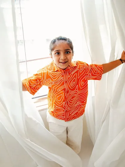 Peek-a-boo. A playful toddler peeking through the curtains, showcasing his fun personality during a studio session.