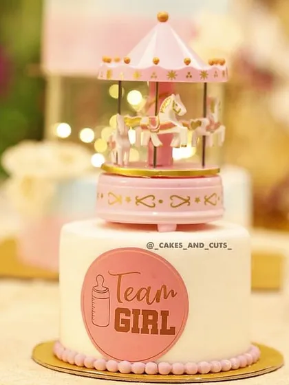 A close-up of the "Team Girl" mini cake with a pink carousel topper. These are always a favorite at baby showers.