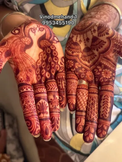 A beautiful peacock design with a rich, dark henna stain. The fingers are adorned with different intricate patterns, showcasing a variety of my skills in one design.