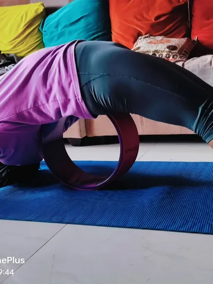 My personal practice often includes a yoga wheel to work on spinal flexibility. Here, I am in a deep backbend, using the wheel to support my spine and open my chest for a healthy, youthful back.